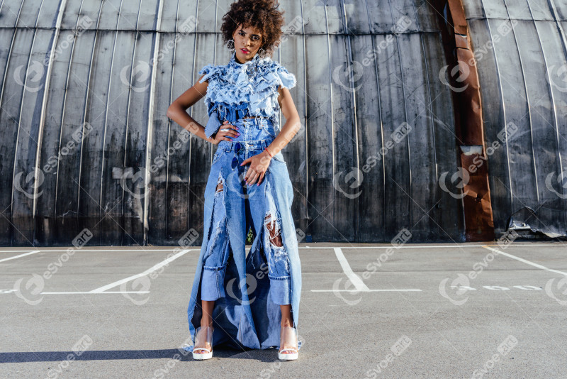 Fashionable african american model posing in denim clothes on parking