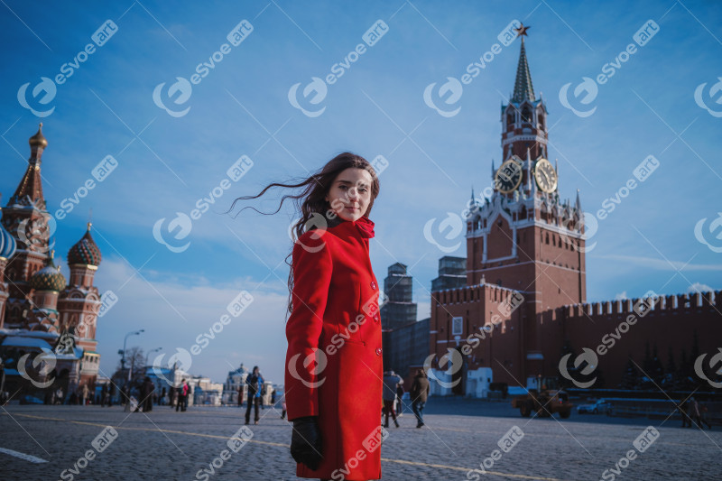 Happy women walking in red coat at the red square in Moscow