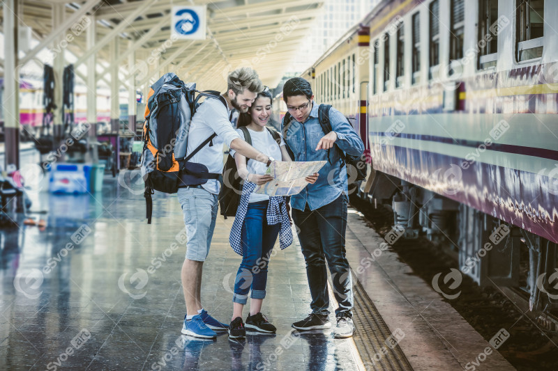 Multiethnic Travellers are looking at the map at the train stati