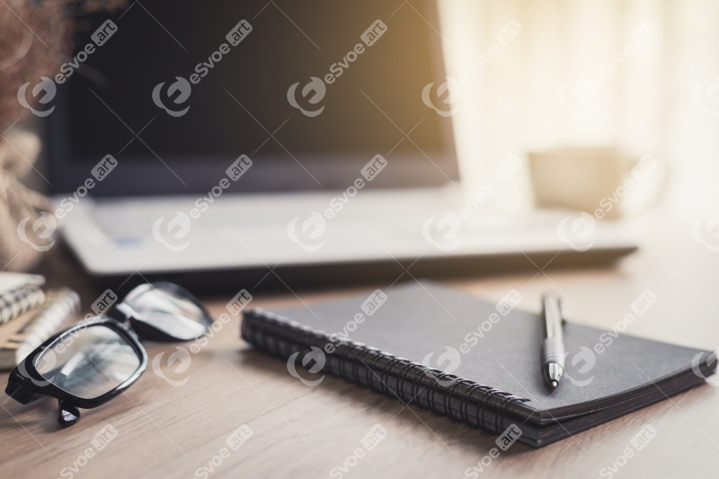 Notebook and laptop in home office with soft light