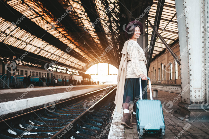 Pretty smiling woman at the railway station posit