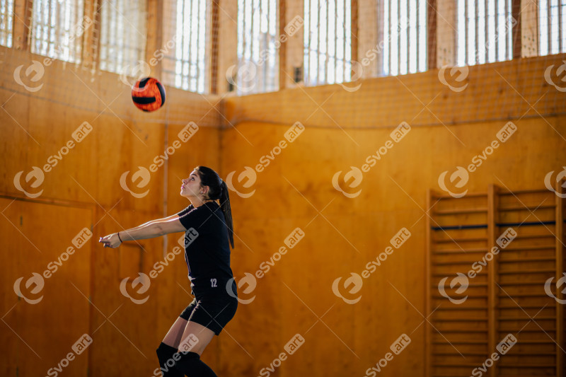 Woman volleyball athlete training or playing a match on an indoor court