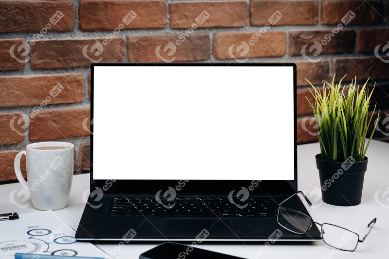 Working desk with blank screen laptop. White computer monitor on the working table. Mockup concept