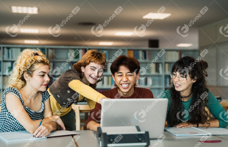 Young university students using laptop and studying with books i